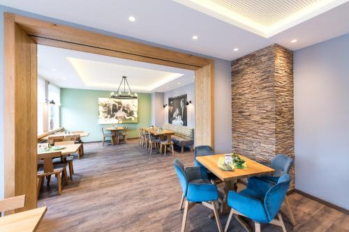 a dining room with wooden tables and blue chairs at Parkhotel Nordwalde in Nordwalde