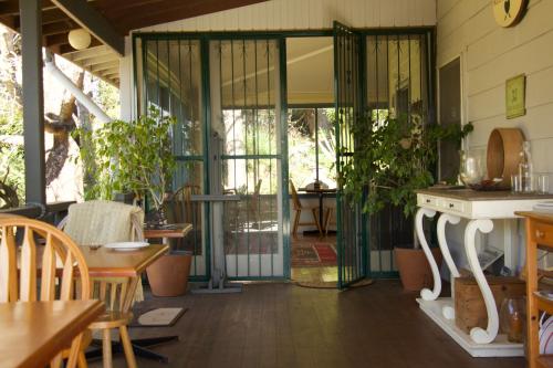 a screened in porch with a table and chairs at Rustic Spirit in Bilpin