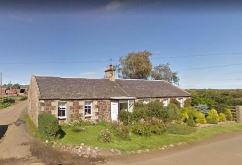 a small stone house on the side of a road at East Linton 3 Bedroom Cottage in East Linton