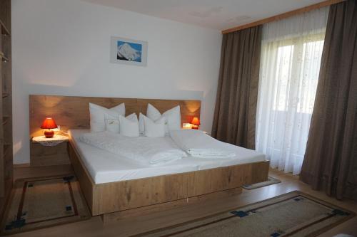ein Schlafzimmer mit einem großen Bett mit weißer Bettwäsche und Kissen in der Unterkunft Haus Dornauer in Hippach