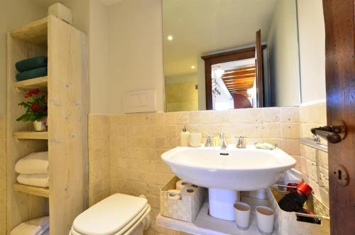 uma casa de banho com um lavatório, um WC e um espelho. em Casa della Nonna C em Gaiole in Chianti