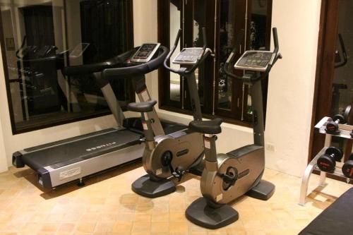 a room with a gym with a treadmill and a mirror at Le Sen Boutique Hotel in Luang Prabang