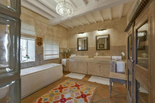 ein großes Badezimmer mit zwei Waschbecken, einer Badewanne und einer Badewanne in der Unterkunft Valliole in Gaiole in Chianti