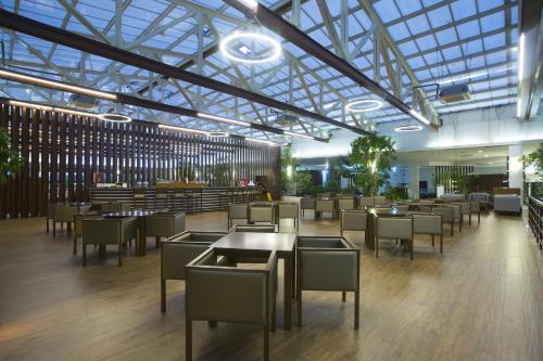 a restaurant with tables and chairs and a glass ceiling at Washington Resort Hotel & Spa in Kizilagac