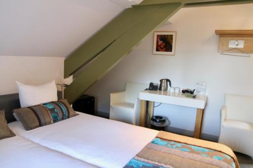 a bedroom with a white bed and a sink at Villa Valkenburg in Valkenburg