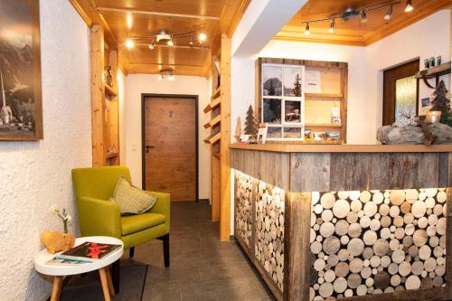 a living room with a green chair and a counter at Alp-Chalet in Hirschegg