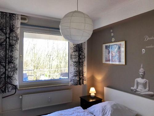 a bedroom with a bed and a window and a lamp at Ferienwohnung Strandkorb in Glücksburg