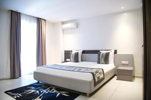 a hotel room with a bed and a large window at Le Ndiambour Hôtel et Résidence in Dakar