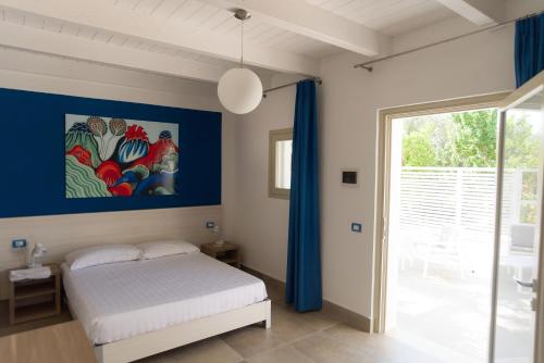 a bedroom with a bed and a painting on the wall at Il Pagliaio B&B in Mattinata