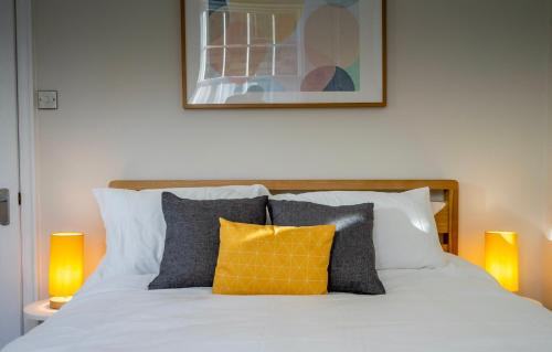 a bed with orange and gray pillows on it at Heart of the City Luxury Apartment in York