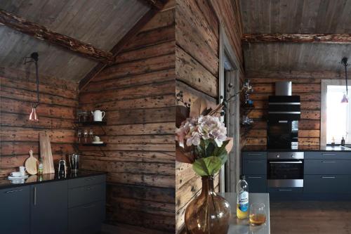 a kitchen with wooden walls and a vase of flowers on a table at Solsiden Brygge Rorbuer in Ballstad