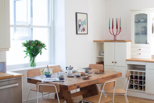 a kitchen with a wooden table and chairs at The Salt House, Fore Street in Ilfracombe