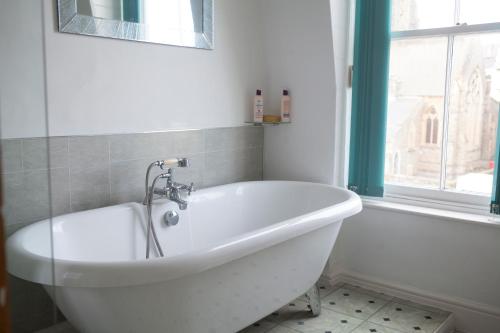 a white bath tub in a bathroom with a window at The Salt House, Fore Street in Ilfracombe