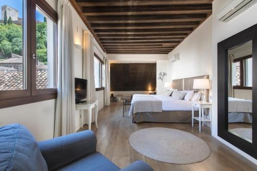 um quarto de hotel com uma cama e uma televisão em Shine Albayzín em Granada