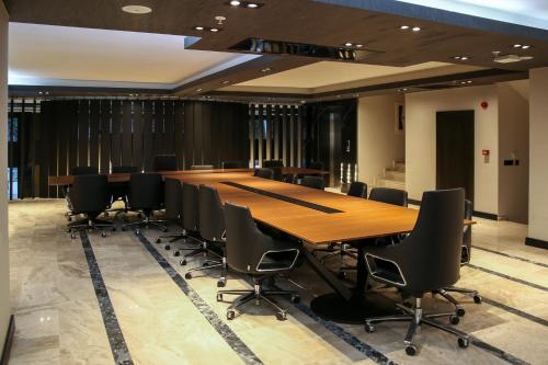 een vergaderzaal met een lange tafel en stoelen bij New Gate Hotel in Ankara