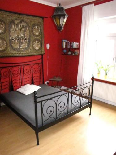 a bedroom with a bed with a red wall at CASA NOSTRA in Wesel