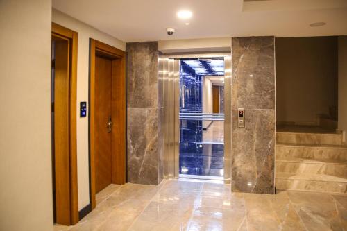 a hallway with a walk in shower and a glass door at New Gate Hotel in Ankara