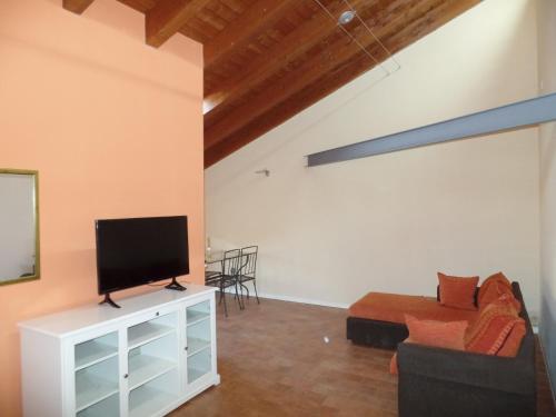 a living room with a tv and a couch at Centralissima mansarda . in Gorizia