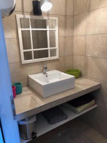 une salle de bain avec un lavabo blanc et un miroir dans l'établissement La Cigale, à Manosque