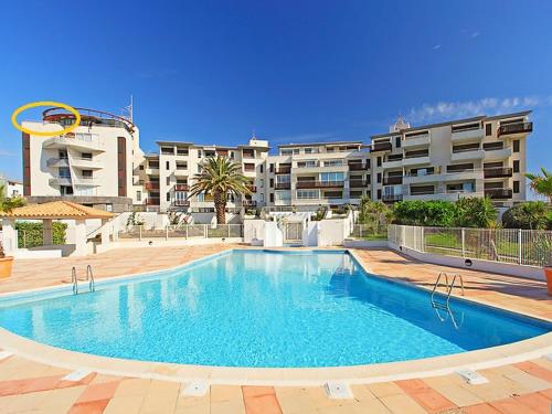 une grande piscine devant un immeuble dans l'établissement appartement 58 m 2 en 1 ere ligne ,vue mer panoramique ,2 terrasses dont une couverte résidence le Sunset, au Cap d'Agde