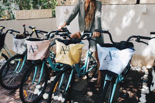 a woman is standing next to a group of bikes at A23 Boutique Hotel in Tel Aviv