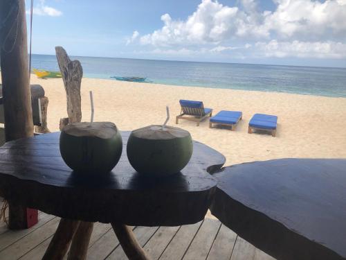 a table on the beach with two bowls on it at White Beach Front and Cottages in Buruanga