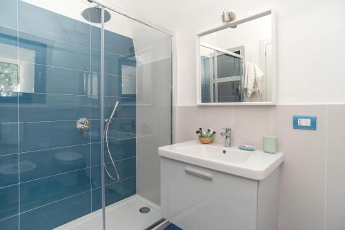 a bathroom with a sink and a glass shower at Il Pagliaio B&B in Mattinata