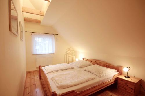 a bedroom with a bed with a wooden headboard and a window at Haus Baabe by Rujana in Baabe