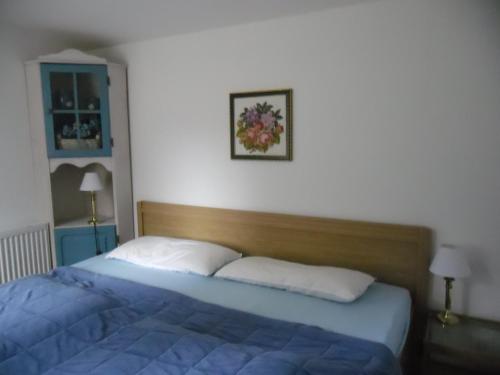 a bedroom with a bed with a blue comforter at Ferienwohnung Prälank in Neustrelitz
