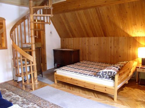a bedroom with a bed and a wooden staircase at Apartmani U Borovoj Šumi in Zlatibor