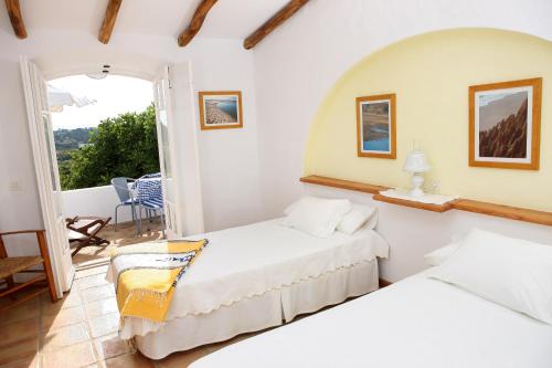 two beds in a room with a balcony at Monte das Cortelhas in Guia