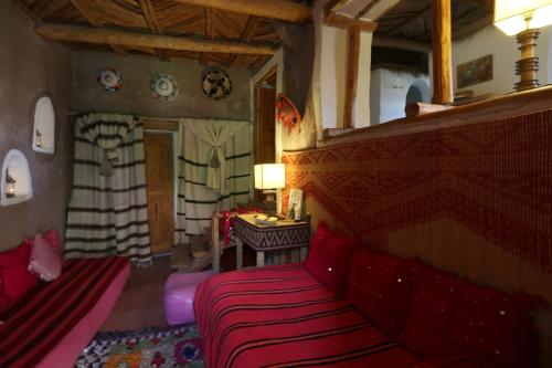 a bedroom with a red bed in a room at Douar Samra in Imlil