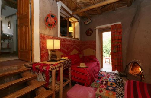 a living room with a red couch and a table at Douar Samra in Imlil