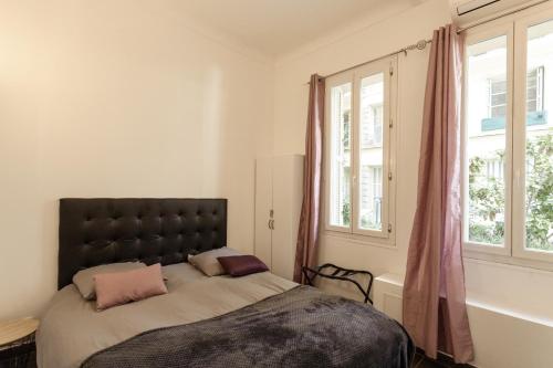 sypialnia z łóżkiem i 2 oknami w obiekcie Apartment proche mer w Nicei