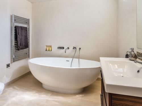 een witte badkamer met een bad en een wastafel bij Fig Tree Villa in Orihuela-Costa