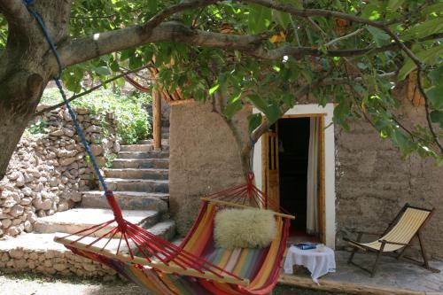 a hammock hanging from a tree in front of a house at Douar Samra in Imlil