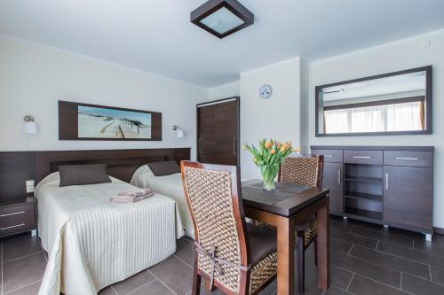 a bedroom with a bed and a table and a desk at Villa Nova 34A in Hel