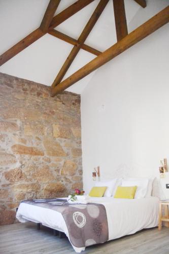 a bedroom with a large bed and a stone wall at Villa Santa Bárbara in Vila Nova de Gaia