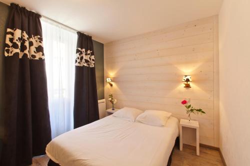 a bedroom with a white bed and a window at Logis Hôtel LBB - les 2 lacs in Clairvaux-les-Lacs