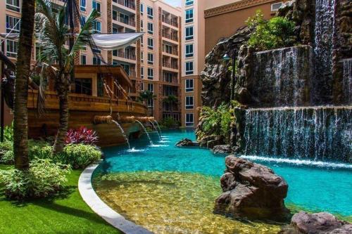 a waterfall in the middle of a pool in a city at Atlantis Condo Resort jomtien in Jomtien Beach