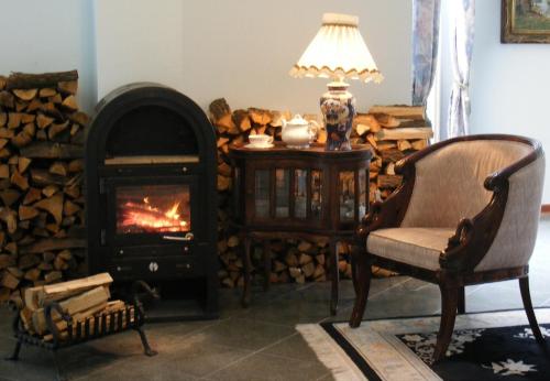 a living room with a fireplace and a chair at Nr 100 Szentendre Hotel Panzio szolgáltatások in Szentendre
