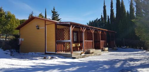 uma pequena cabana na neve na floresta em Camping Castillo de Loarre em Loarre