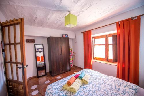 a bedroom with a bed with two towels on it at Las Huertas in Monachil