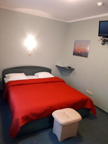 a bedroom with a bed with a red blanket at Minhauzena Unda in Saulkrasti