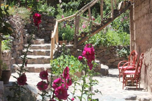 a garden with red flowers and a stone staircase at Douar Samra in Imlil