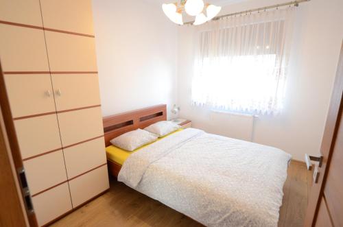 a small bedroom with a bed and a window at Apartament Malta Poznań in Poznań