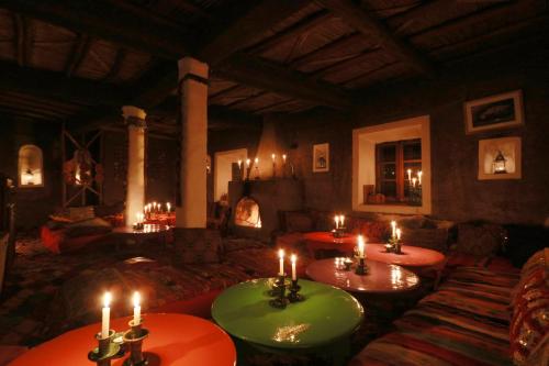 a living room with two tables and a fireplace at Douar Samra in Imlil