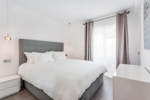 Un dormitorio blanco con una cama grande y una ventana en by RIVA - Gorgeous 2 Bedroom Apartment in Centre of Puerto Banus, en Marbella