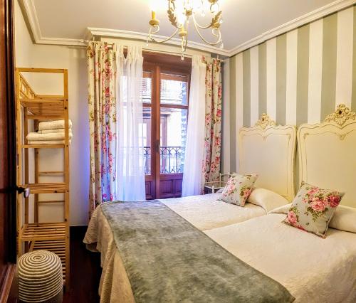 a bedroom with two beds and a window at La Casa de Lorenzo in Laguardia