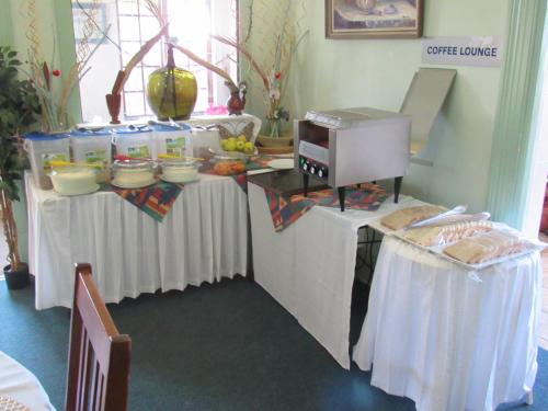 a buffet with white tables with food on them at Concord Christian Guesthouse in Durban